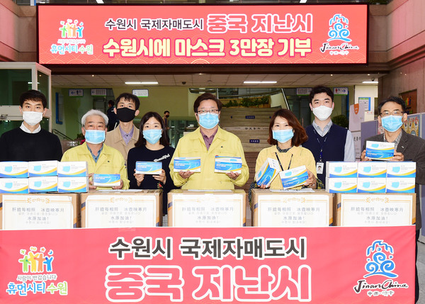 염태영 수원시장과 공직자들이 중국 지난시에서 보내 준 마스크 상자를 앞에 두고 기념촬영을 하고 있다. ⓒ 뉴스피크