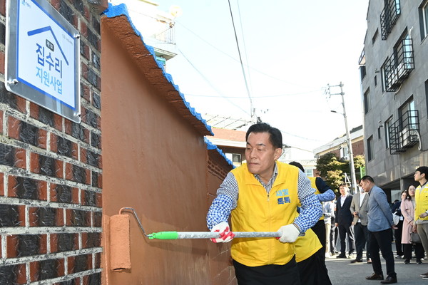 ▲ 이재준 수원시장이 지난해 10월 수원형 저층주거지 집수리 지원사업 1호 기념식에서 페인트를 칠하고 있다.