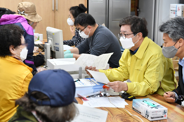 염태영 수원시장(오른쪽)이 20일 권선구 권선1동행정복지센터에서 재난기본소득을 신청하는 시민에게 방법을 안내하고 있다. ⓒ 뉴스피크