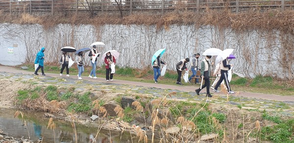 ▲ ‘세계 물의 날’ 행사에 참석한 시민들이 수원천 주변의 쓰레기를 치우고 있다. ⓒ 뉴스피크