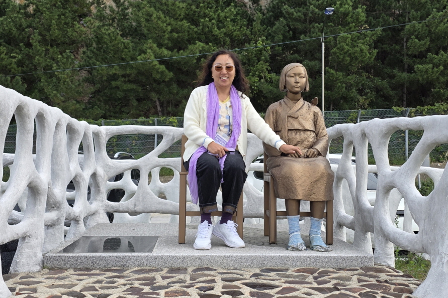 ▲ 수원평화나비 김향미 공동대표가 10월 31일 오후 사단법인 수원민주화운동계승사업회 주최 ‘광복 80주년 기념 독도 수호 탐방’ 중 울릉군 서면 학포마을 소재 송담복지재단에 있는 평화의 소녀상과 함께 기념사진을 찍고 있다. (사진 : 김향미)