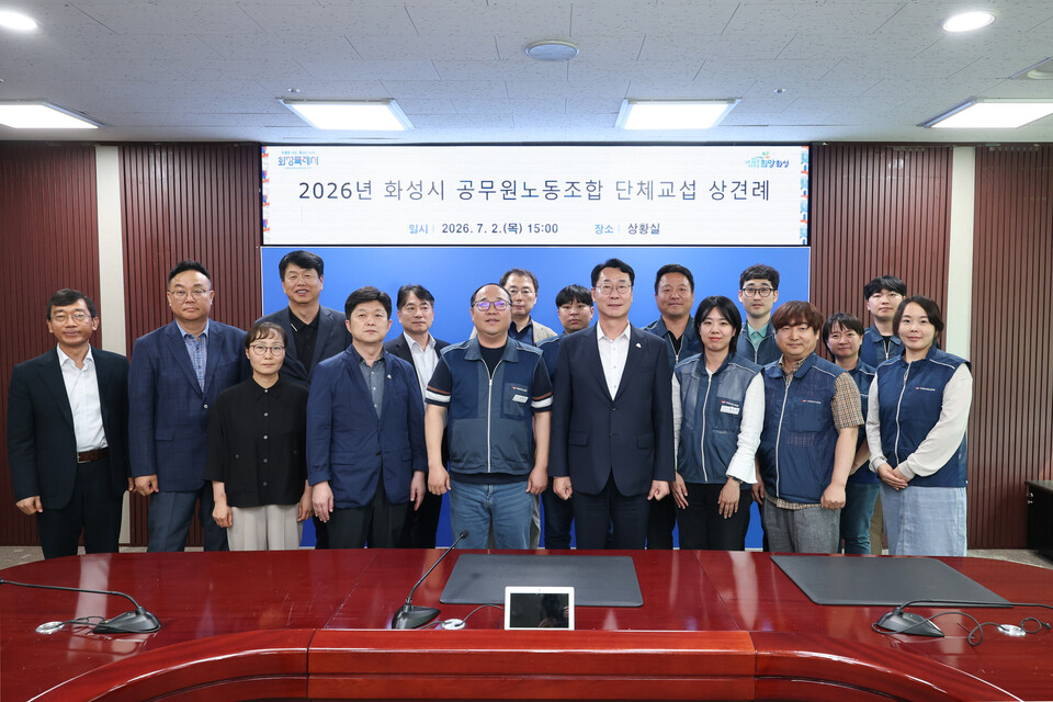 ▲ 정명근 화성특례시장과 최태성 전국공무원노동조합 화성특례시지부장이 7월 2일 시청 상황실에서 열린 2026년 화성시 공무원노동조합 단체교섭 상견례 참석자들과 기념촬영을 하고 있다.